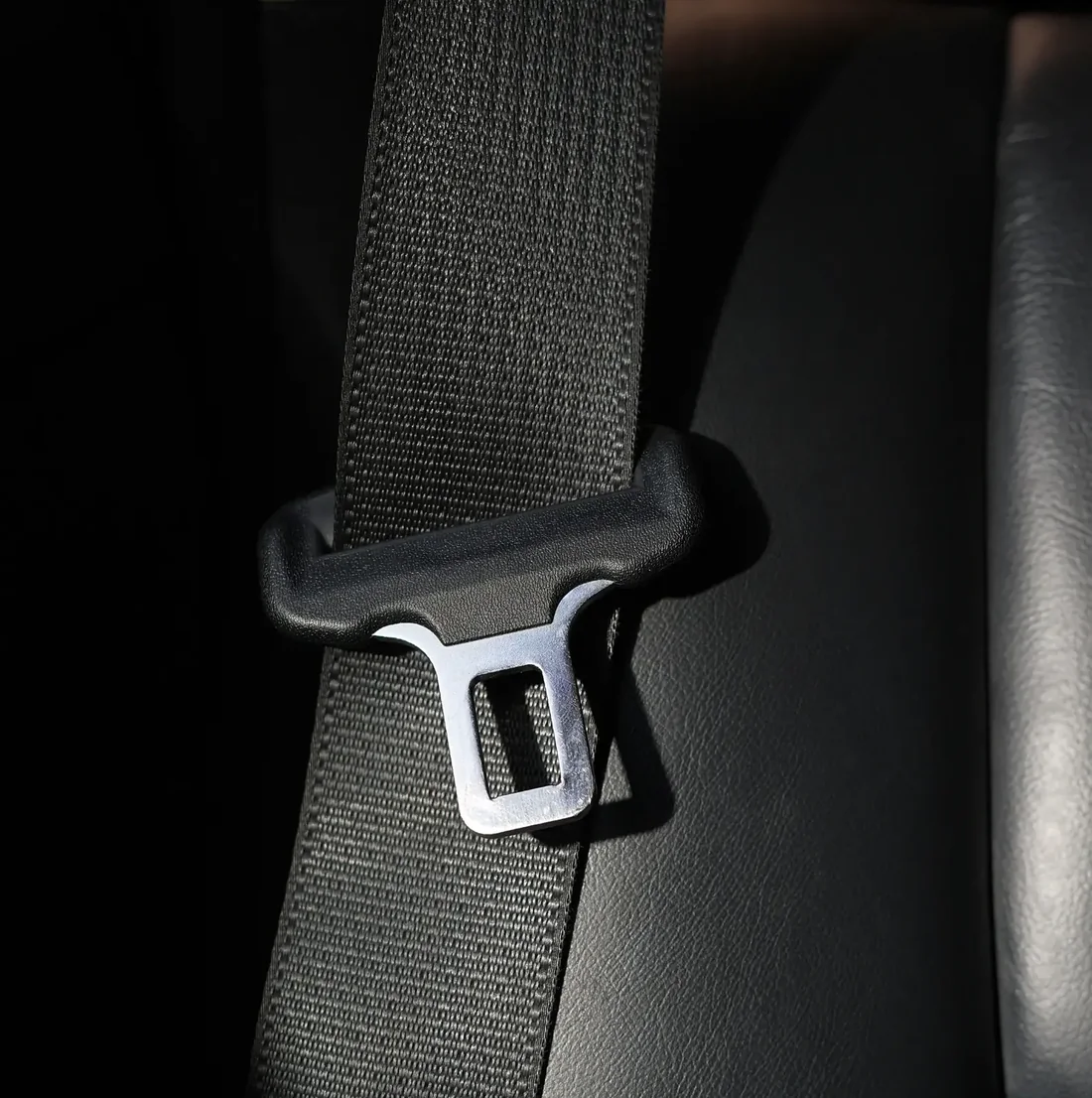 Close detail of seat belt webbing and metal latch plate hardware
