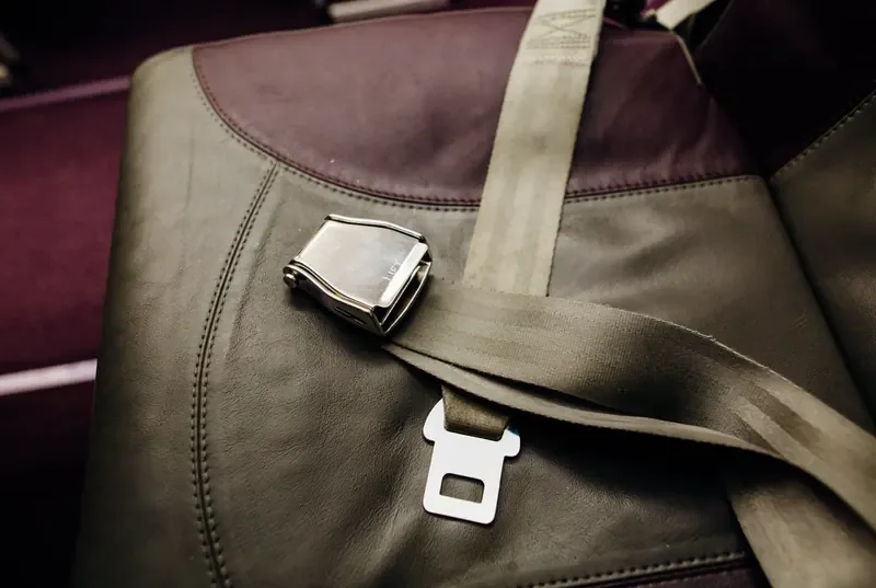 Two-point lap belt with a metal buckle fitted across a bench seat