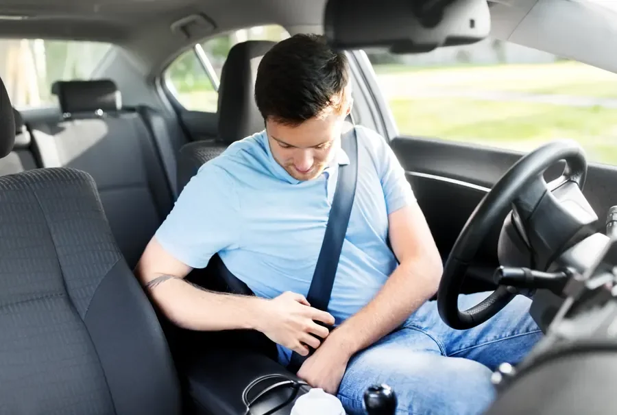 Driver fastening a seat belt inside a vehicle