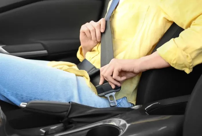 Occupant fastening a seat belt in a vehicle during a routine check