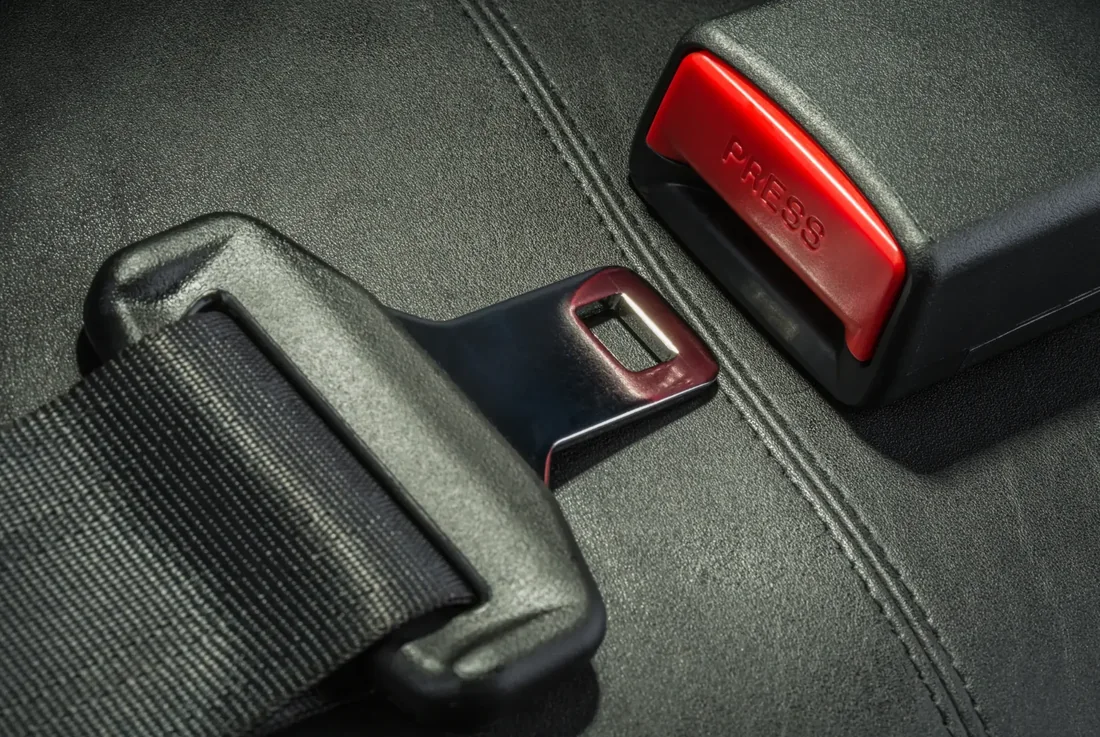 Seat belt latch plate and buckle receiver shown in detail on a vehicle seat