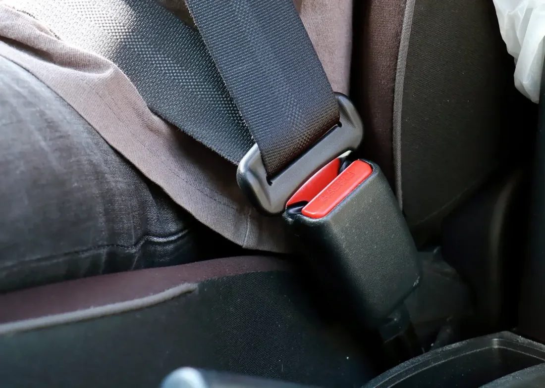 Seat belt webbing running across an occupant with the buckle engaged